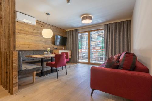 a living room with a red couch and a table at Sport Apart in Zell am Ziller