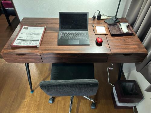 a wooden desk with a laptop computer on it at Cool-Residence OTARU in Otaru