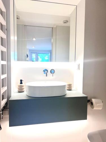 a bathroom with a white sink and a mirror at Costa Apartments in Sopot