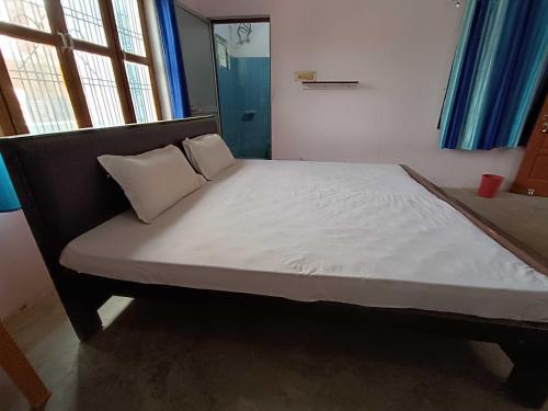 a bed with two pillows on it in a room at OYO Home Anjaneya Guest House Homestay in Ayodhya