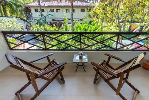 a balcony with two chairs and a table at Kalipay Resort Siargao in General Luna