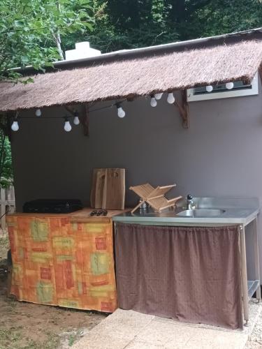 a outdoor kitchen with a table and a sink at Git'an Périgord la Bonne aventure in Groléjac