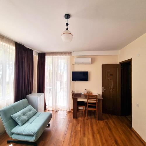 a living room with a blue couch and a desk at GiNa Shekvetili in Shekvetili