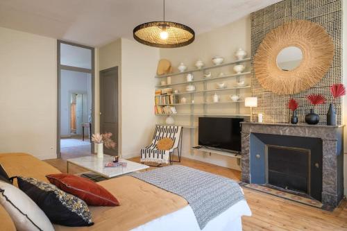 uma sala de estar com lareira e televisão em Appartement avec son patio dans centre historique de Bourg em Bourg-sur-Gironde