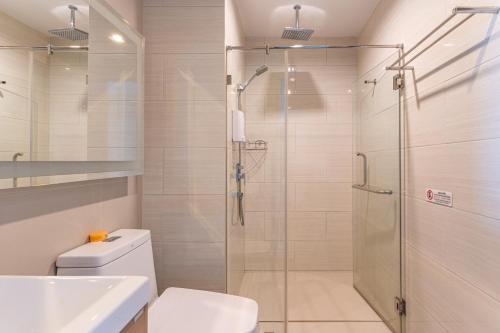 a bathroom with a shower and a toilet and a sink at Aeras beachfront 1 bedroom in Jomtien Beach