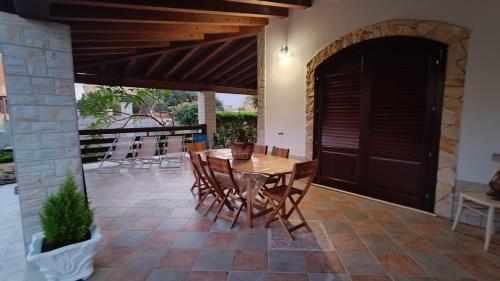 a patio with a wooden table and chairs at VILLA HELENA in Lampedusa