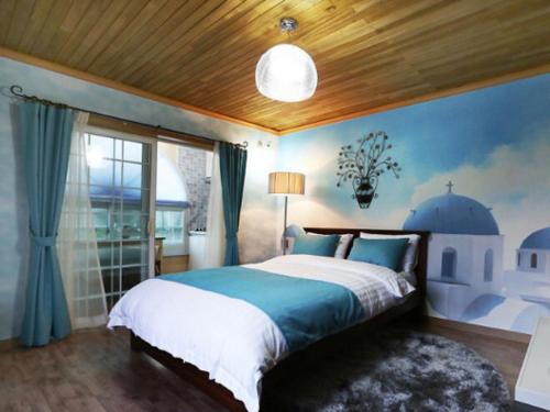 sypialnia z dużym łóżkiem i oknem w obiekcie Solemio Pension w mieście Geoje