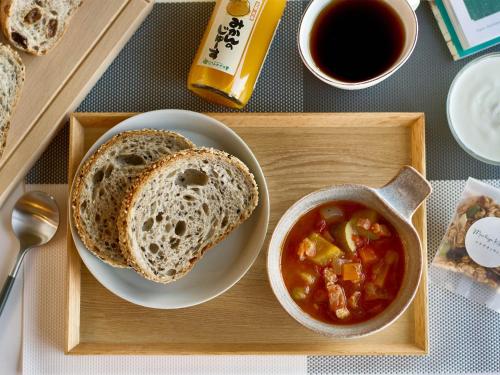 a tray with a plate of bread and a bowl of soup at THE MACHIYA EBISUYA in Kyoto