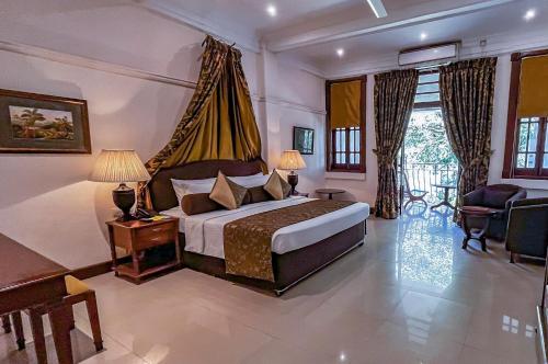 ein Schlafzimmer mit einem Kingsize-Bett in einem Zimmer in der Unterkunft Hotel Suisse in Kandy