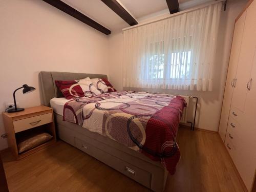 een kleine slaapkamer met een bed en een raam bij Vineyard cottage Pri Krakaru in Dragatuš