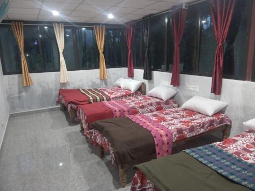 two beds in a room with red curtains at Uppinagadde Home stay in Kalasa