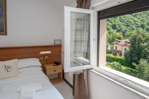 1 dormitorio con cama y ventana grande en Hotel Villa Elia, en Calizzano