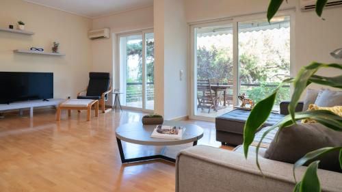 una sala de estar con un sofá y una mesa en Vouliagmeni Honeymoon Suite, en Atenas