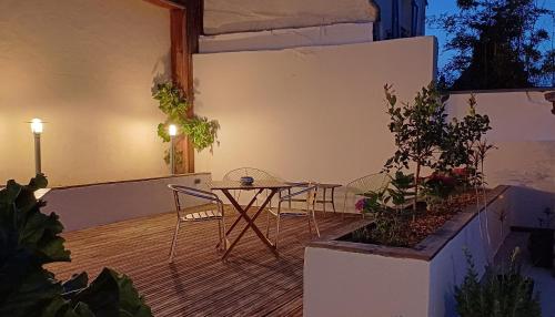 a patio with a table and chairs and plants at Un B&B à Loktudi in Loctudy