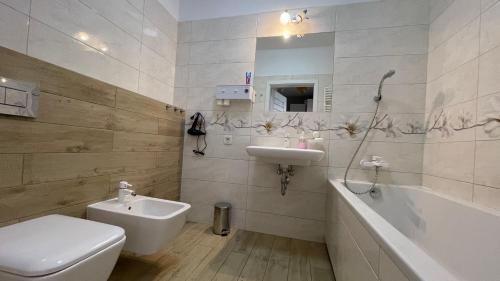 łazienka z toaletą, umywalką i wanną w obiekcie Apartamenty Warszawa Centrum Włodarzewska 30 m45 w Warszawie