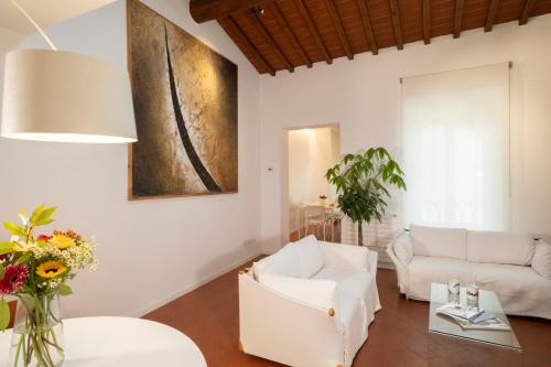 a living room with white furniture and a painting on the wall at San Niccolò City Walls Garden in Florence
