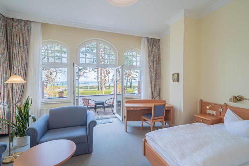 a hotel room with a bed and a table and chairs at Hotel Imperial Rügen in Binz