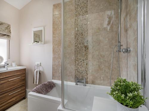 a bathroom with a shower with a white tub at Melie-rose in Aberdare