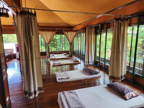 a room with four beds in it with windows at Coral Bungalows in Haad Rin