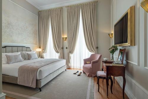 a hotel room with a bed and a chair at MS Collection Aveiro - Palacete Valdemouro in Aveiro