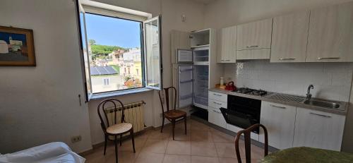 a kitchen with chairs and a sink and a window at Casa Giusto Ischia in Ischia
