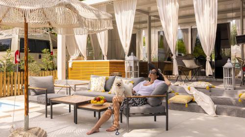 une femme assise sur un canapé avec un chien dans l'établissement Polidor Camping Resort, à Poreč