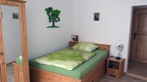 Dormitorio pequeño con cama con sábanas verdes en Gästezimmer zum rotem Karpfen, en Erfurt