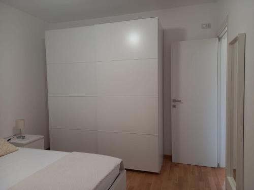 a white bedroom with a bed and a closet at Aura Apartments - Orizzonte Turismo in Porto Cesareo