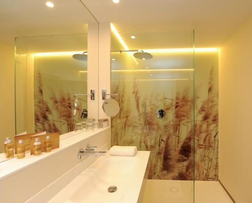 a bathroom with a sink and a shower at Hotel Vier Jahreszeiten in Silandro