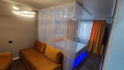 - un salon avec un canapé et une fenêtre dans l'établissement Уютная люкс квартира в центре, à Uralsk