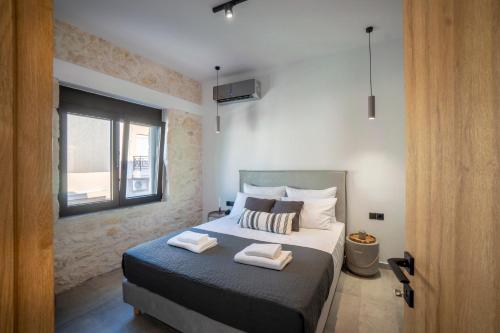 a bedroom with a bed with two towels on it at FLOR28 STONE HOUSE in Heraklio