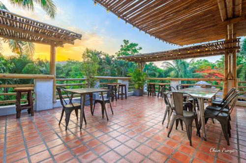 a restaurant with tables and chairs on a patio at Baanpong Lodge in San Kamphaeng