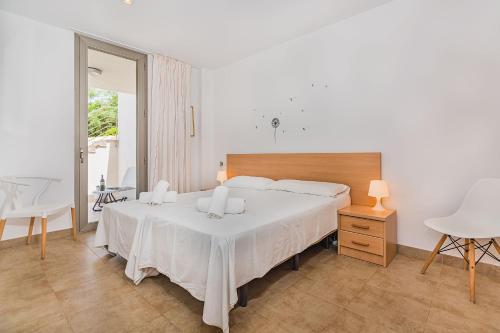 カラ・デ・サント・ビセントにあるMOLINS 1のベッドルーム1室(白いベッド1台、テーブル、窓付)