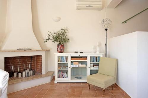 a living room with a chair and a fireplace at The Blooming House in Makriótika