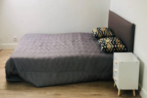 ein großes Bett in einem Schlafzimmer mit einem Nachttisch in der Unterkunft Studio Très Agréable en Hyper Centre, 50 m du Port in Vannes