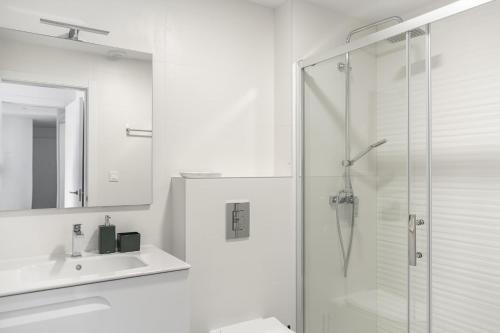 ein Bad mit einer Dusche, einem Waschbecken und einem Spiegel in der Unterkunft Rennes Arenal Playa 3 in Jávea