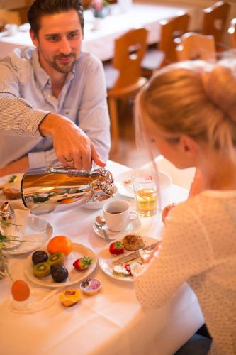 a man and woman sitting at a table eating food at Landgasthof-Wemmer in Großrückerswalde
