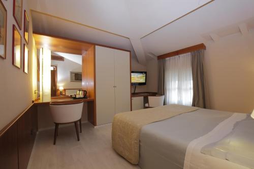 a hotel room with a bed and a desk at Albergo Celide in Lucca