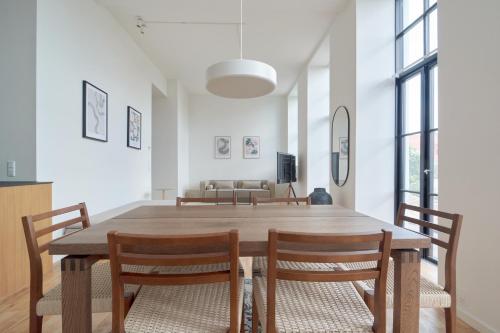 a dining room with a wooden table and chairs at Cozy and Bright Apartments with Private Car Park in Copenhagen