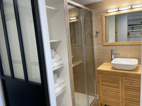 a bathroom with a shower and a sink and a mirror at CAPAO Beach Hôtel in Cap d'Agde