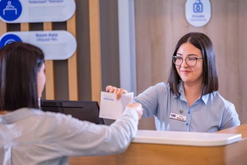 a woman handing another woman a piece of paper at Holiday Inn Express - Yerevan by IHG in Yerevan