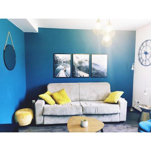 a living room with blue walls and a couch at L'émeraude in Le Bourg-dʼOisans