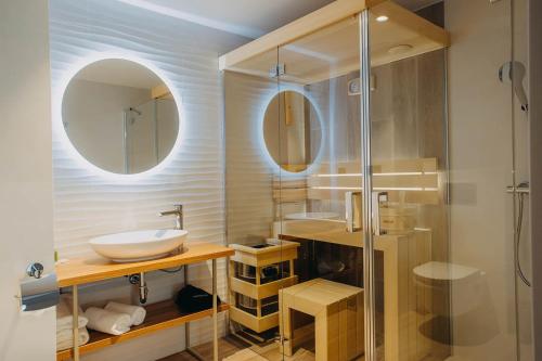 ein Bad mit einem Waschbecken und einer Glasdusche in der Unterkunft Platinum Adults in Szklarska Poręba
