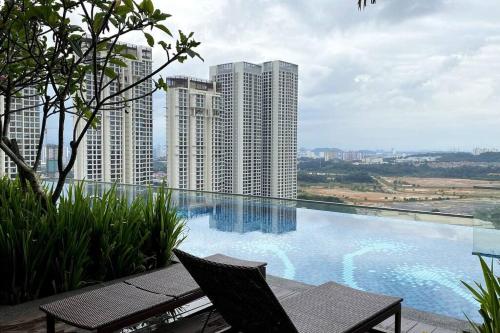 een zwembad met een tafel en stoelen en gebouwen bij Super King-Sized Studio-Revo in Kuala Lumpur