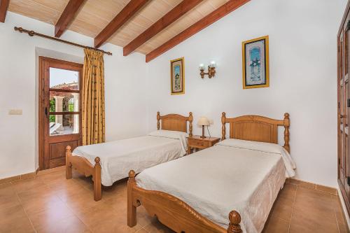 2 camas en una habitación con ventana en Malagarba, en Pollensa