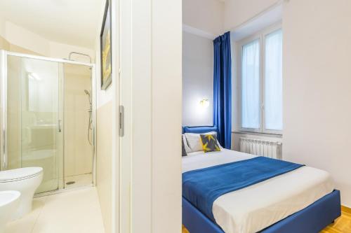 1 dormitorio con cama, aseo y ducha en Chiatamone Design Apartment by Wonderful Italy en Nápoles