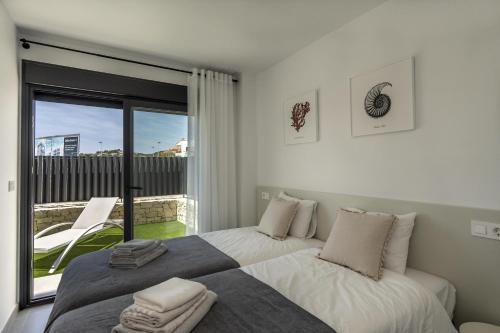 a bedroom with two beds and a balcony at Rennes Arenal Playa 6 in Jávea