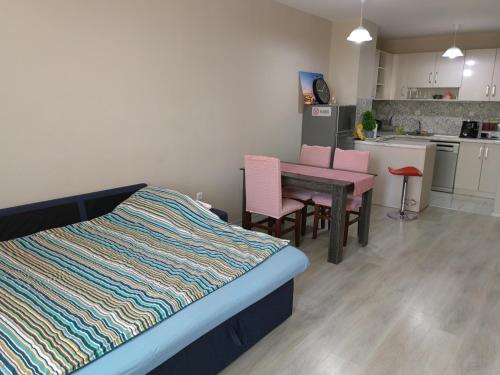 1 dormitorio con 1 cama, mesa y sillas en Двустаен апартамент в Смирненски. До селената en Plovdiv