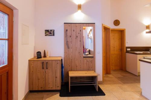 a kitchen with a wooden cabinet and a table in a room at Schleipfnerhof Urlaub auf dem Bauernhof in Bernau am Chiemsee
