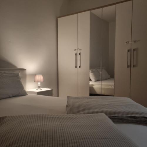 a bedroom with two beds and a mirrored cabinet at Apartmani Katarina 4+2 in Biograd na Moru